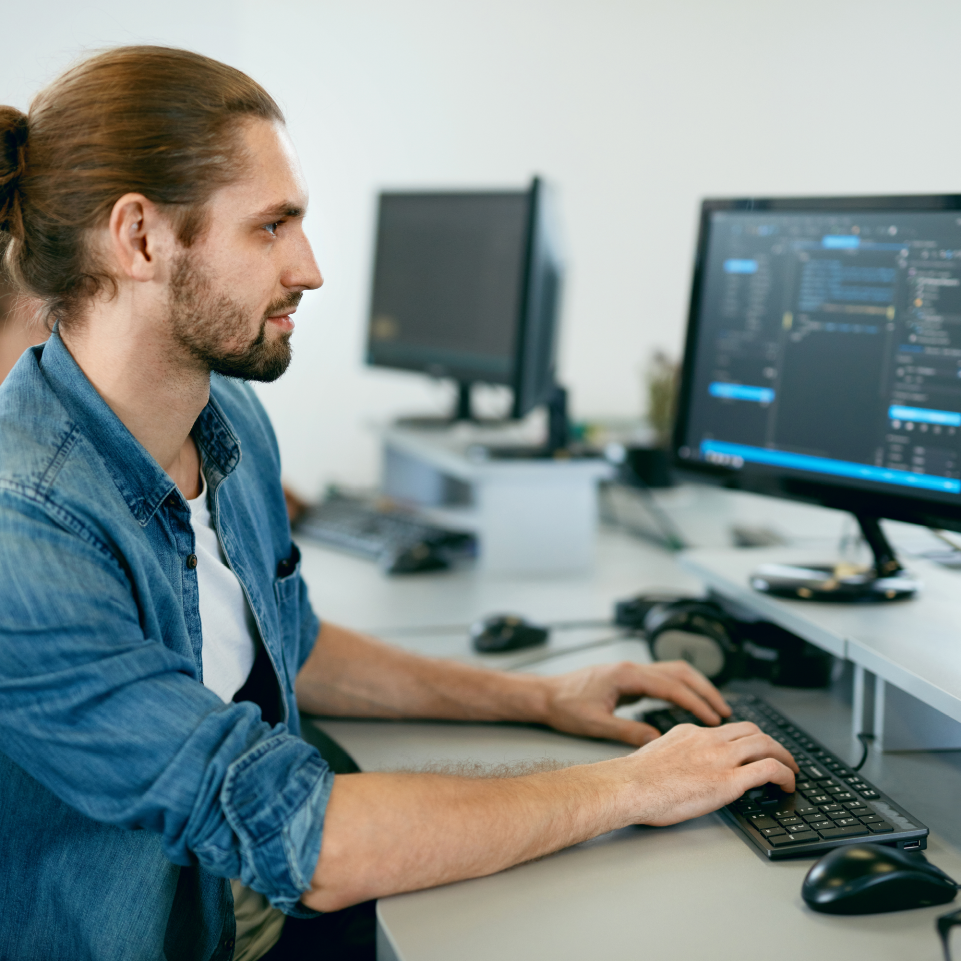 Homme qui écrit des codes sur un ordinateur, dans un bureau informatique